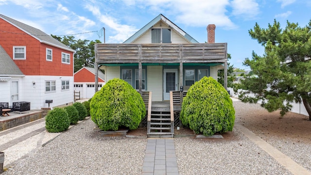 55 W 22nd St, Avalon, NJ 08202 - view of front of house featuring an outbuilding, covered porch, a chimney, stairs, and a detached garage
