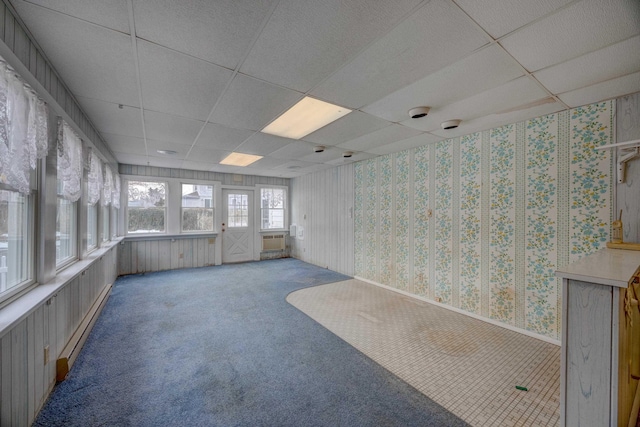 interior space featuring carpet, a baseboard heating unit, and a drop ceiling