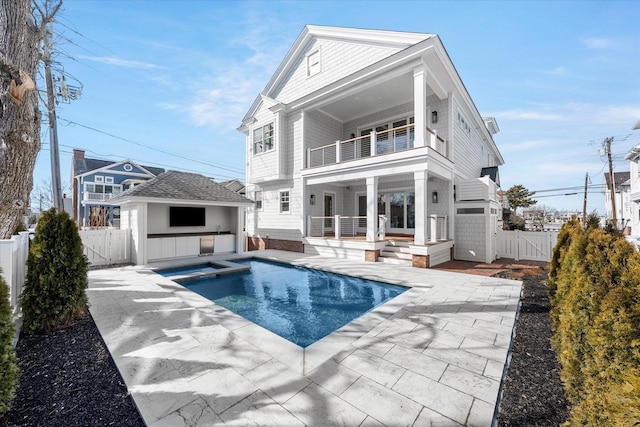 274 106th St, Stone Harbor, NJ 08247 - back of property featuring a balcony, a patio, a gate, a fenced backyard, and a pool with connected hot tub
