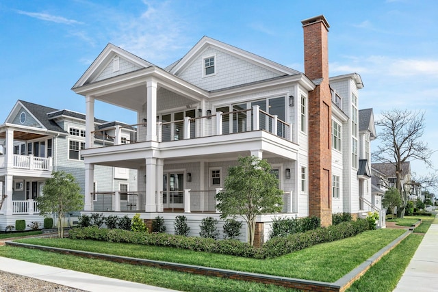 neoclassical home with a balcony and a front yard