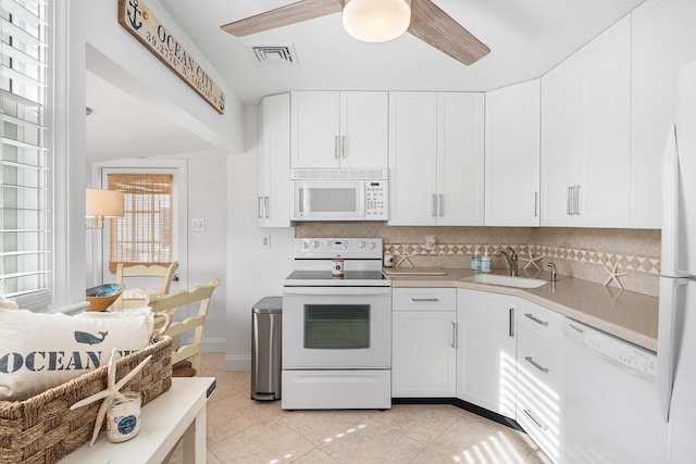 kitchen with a ceiling fan, tasteful backsplash, a sink, light countertops, and white appliances