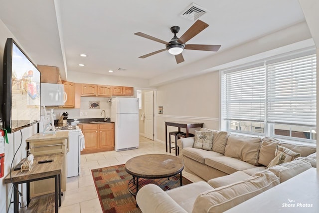 tiled living room with ceiling fan and sink