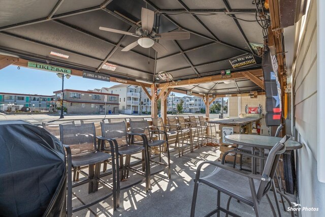 view of patio / terrace featuring a gazebo, ceiling fan, area for grilling, and a bar