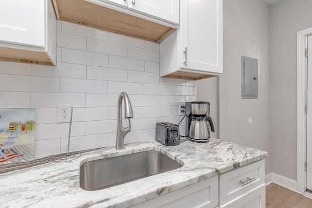 222 E Burk Ave Unit 4, Wildwood, NJ 08260 - kitchen featuring a sink, white cabinets, backsplash, electric panel, and light stone countertops