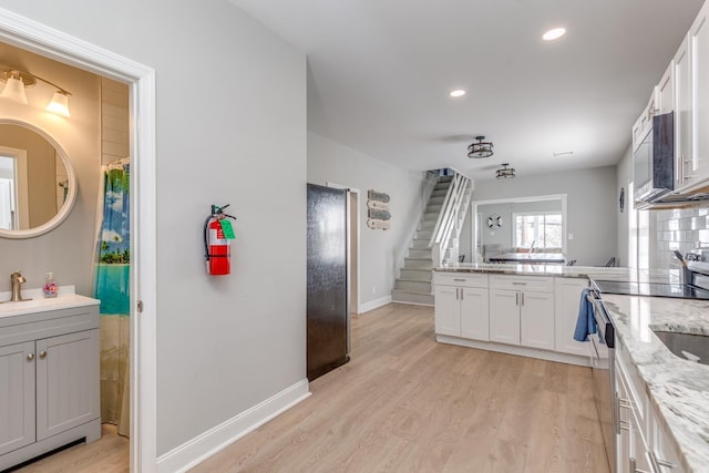 222 E Burk Ave Unit 4, Wildwood, NJ 08260 - kitchen featuring light wood-style floors, recessed lighting, a peninsula, light stone countertops, and baseboards