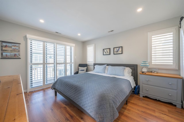 bedroom featuring dark wood-style floors, recessed lighting, visible vents, access to outside, and baseboards