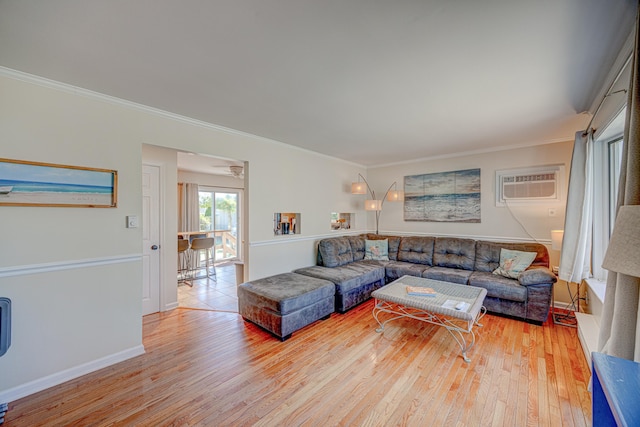 living room with baseboards, light wood-type flooring, a wall unit AC, and ornamental molding
