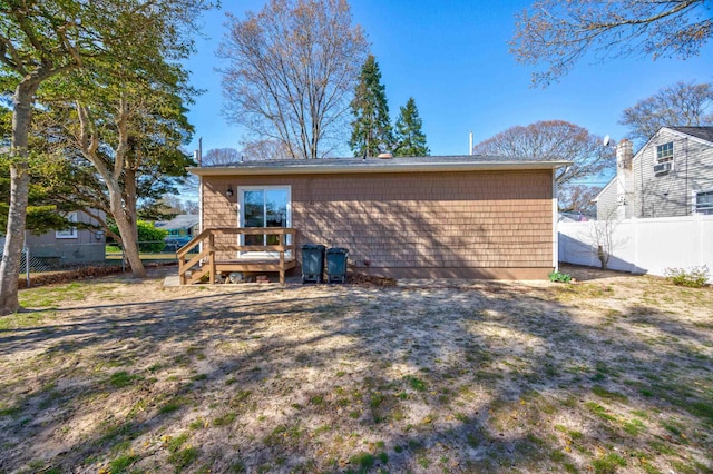 back of property with fence and a deck