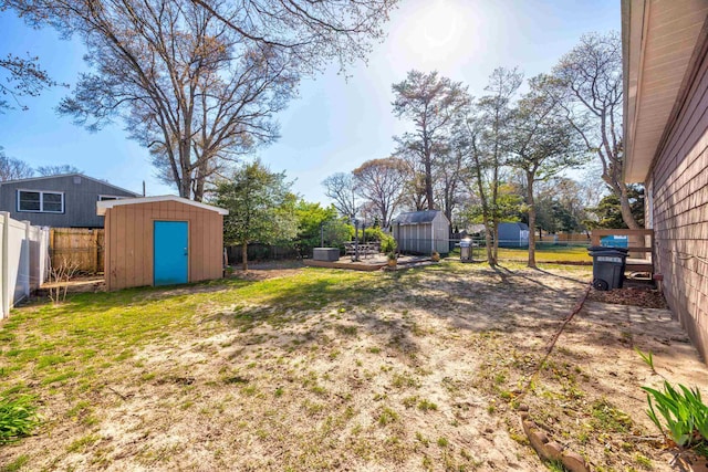 view of yard featuring an outdoor structure, a shed, and a fenced backyard