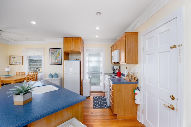 kitchen featuring crown molding, sink, white appliances, and light hardwood / wood-style floors