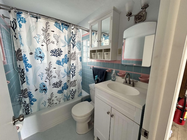 full bathroom featuring vanity, tile walls, shower / tub combo, and toilet