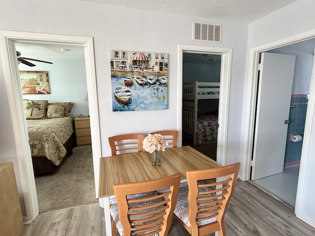 dining room featuring wood-type flooring and a textured ceiling