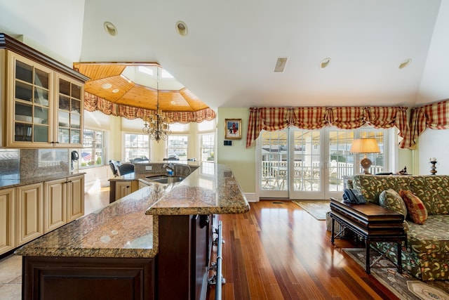 2404 Atlantic Ave, Longport, NJ 08403 - kitchen featuring cream cabinetry, wood finished floors, vaulted ceiling, glass insert cabinets, and dark stone counters