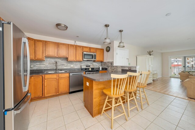 227 E Leaming Ave Unit A, Wildwood, NJ 08260 - kitchen featuring stainless steel appliances, a sink, light tile patterned flooring, decorative backsplash, and dark countertops