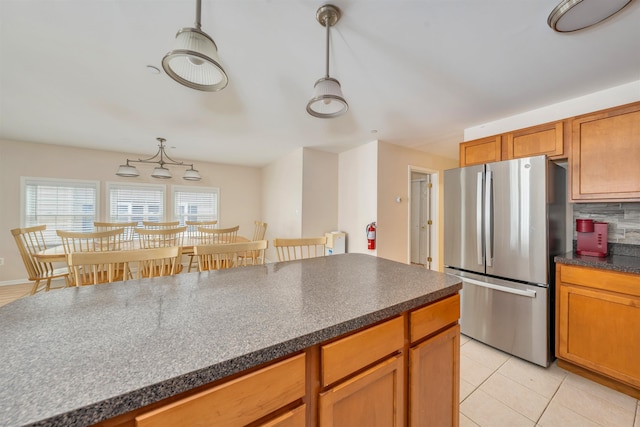 227 E Leaming Ave Unit A, Wildwood, NJ 08260 - kitchen with freestanding refrigerator, dark countertops, backsplash, light tile patterned flooring, and brown cabinets