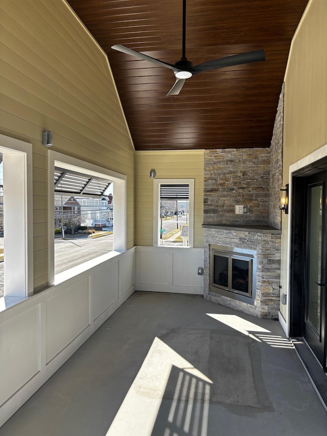 interior space featuring wood ceiling, ceiling fan, lofted ceiling, and an outdoor stone fireplace