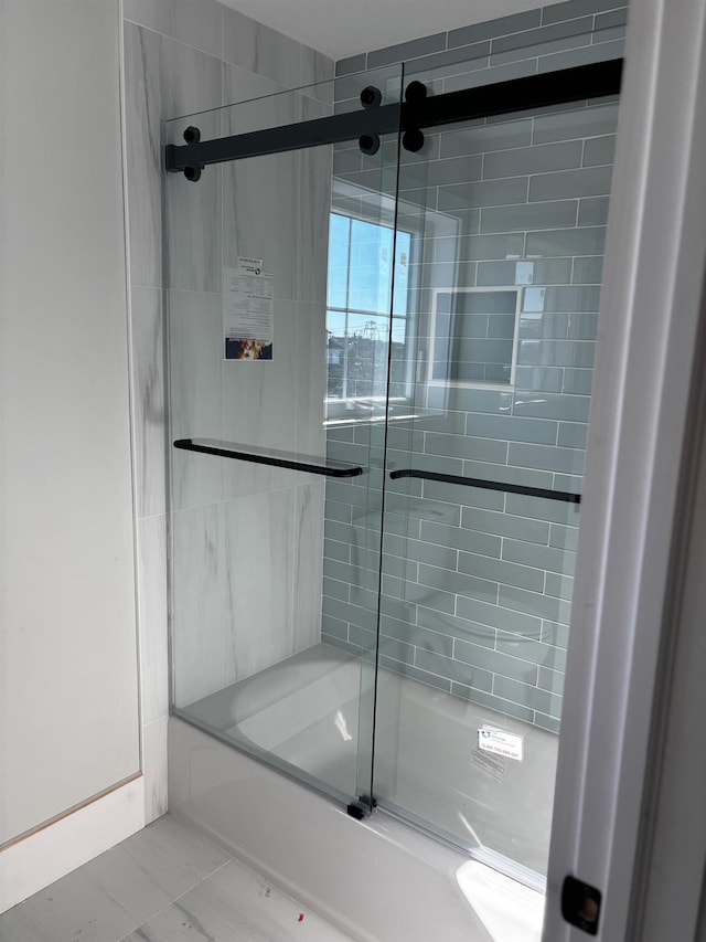 bathroom with shower / bath combination with glass door