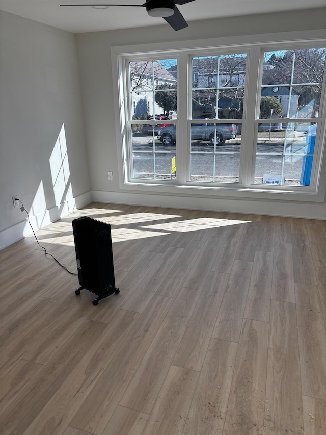 unfurnished living room featuring ceiling fan and light hardwood / wood-style flooring