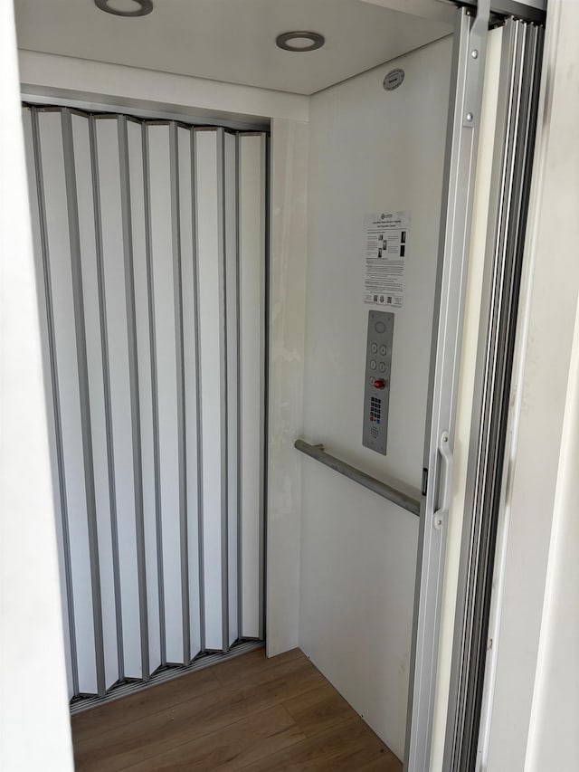 details with elevator and wood-type flooring