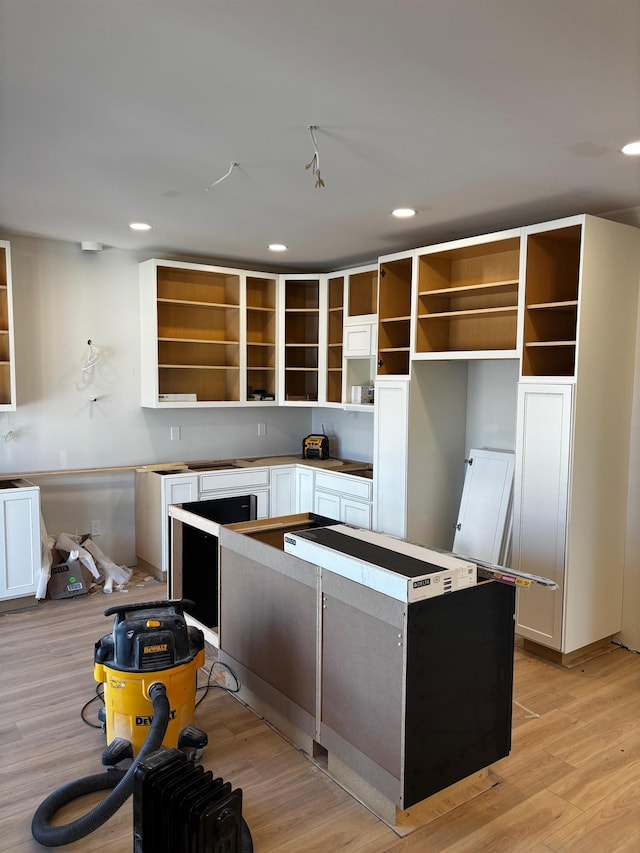 kitchen featuring a center island, white cabinets, and light wood-type flooring