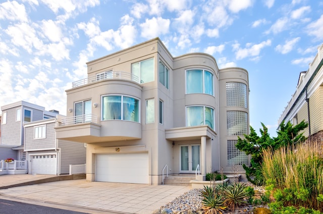 view of front of property featuring french doors, a balcony, and a garage