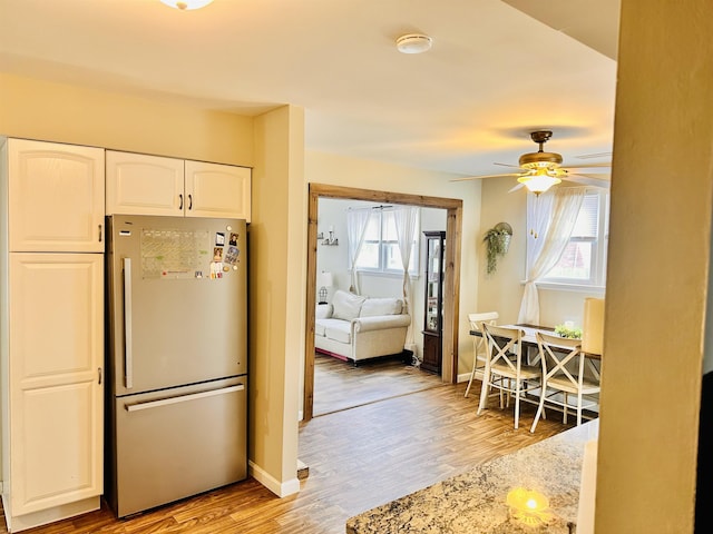 203 E Vermont Ave, Rio Grande, NJ 08242 - kitchen featuring a ceiling fan, baseboards, light wood finished floors, freestanding refrigerator, and white cabinets