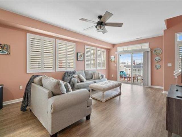 living room with ceiling fan and light hardwood / wood-style flooring