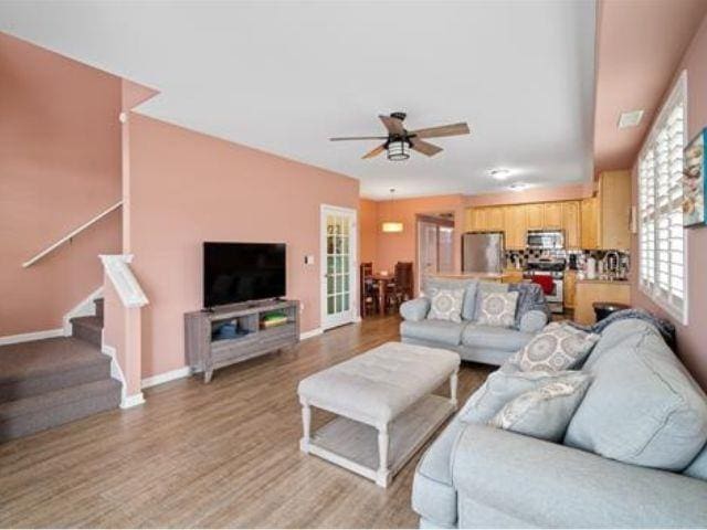 living room featuring light hardwood / wood-style flooring and ceiling fan