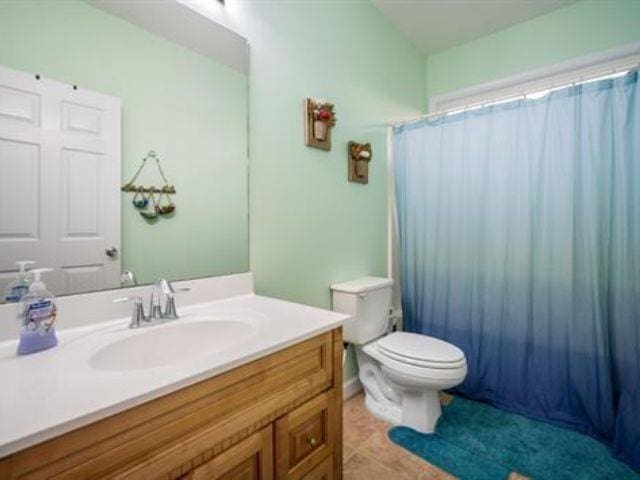 full bathroom featuring vanity, toilet, tile patterned flooring, and shower / bath combo