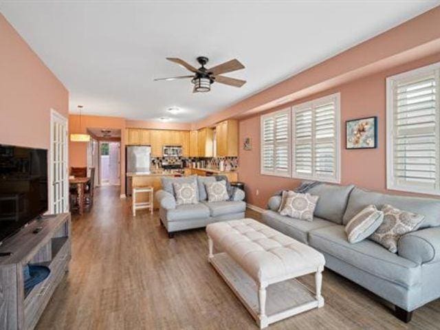 living room featuring hardwood / wood-style floors and ceiling fan