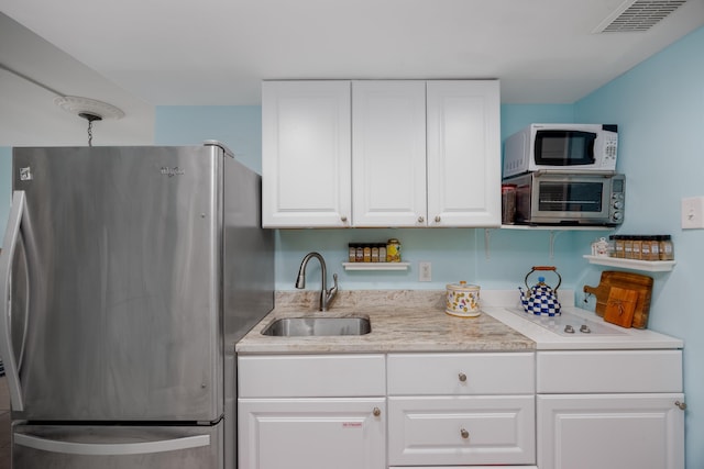 8401 Atlantic Ave Unit 310, Wildwood Crest, NJ 08260 - kitchen featuring visible vents, appliances with stainless steel finishes, a sink, light stone counters, and white cabinets