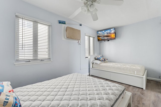 bedroom featuring vaulted ceiling, a ceiling fan, and wood finished floors