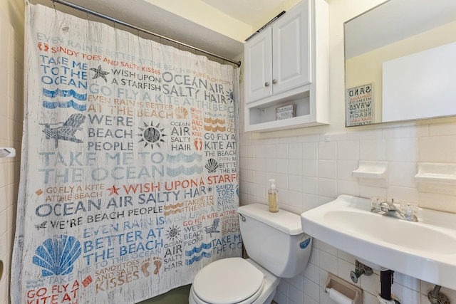 bathroom with a shower with shower curtain, toilet, tile walls, and a sink