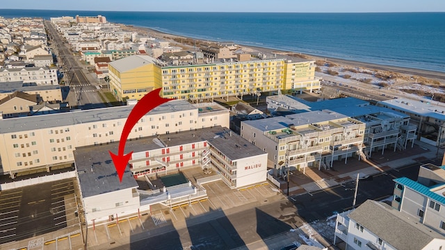 drone / aerial view with a water view and a beach view