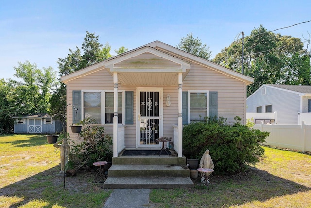 bungalow-style home with a shed and a front lawn