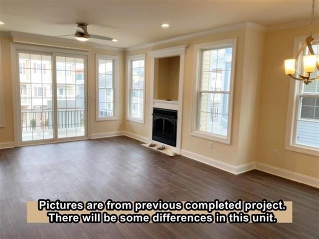 unfurnished living room featuring ceiling fan with notable chandelier, dark hardwood / wood-style floors, and crown molding