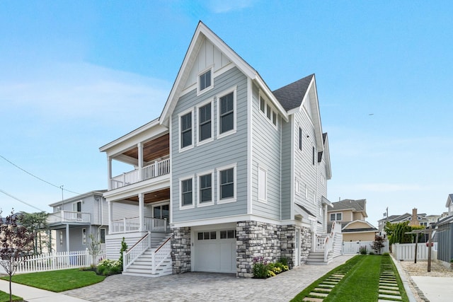 286 75th St, Avalon, NJ 08202 - view of front of house featuring stairs, a balcony, stone siding, and a garage