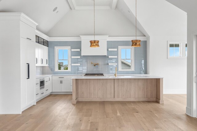 286 75th St, Avalon, NJ 08202 - kitchen featuring vaulted ceiling, light wood-style flooring, light countertops, decorative backsplash, and a center island