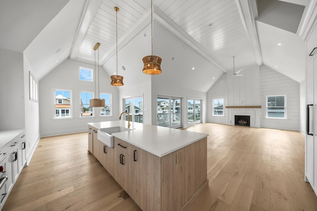 286 75th St, Avalon, NJ 08202 - kitchen featuring a sink, a ceiling fan, light wood-style floors, a center island with sink, and light countertops