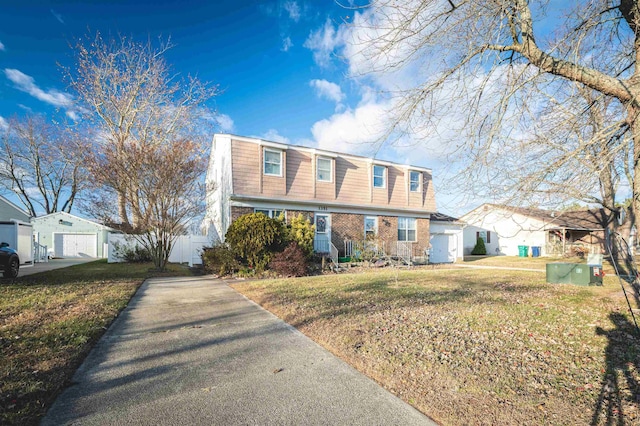 view of front property with a front yard, a garage, and an outdoor structure