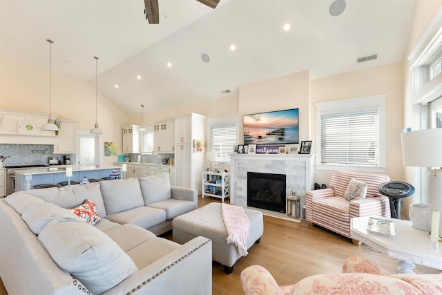 149 10th St, Avalon, NJ 08202 - living room with light wood-style floors, high vaulted ceiling, a tile fireplace, and a ceiling fan