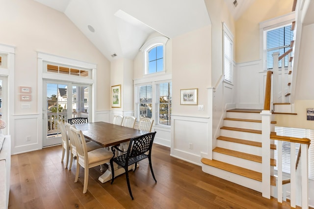 149 10th St, Avalon, NJ 08202 - dining area featuring a wainscoted wall, high vaulted ceiling, plenty of natural light, hardwood / wood-style floors, and stairs