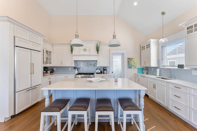 149 10th St, Avalon, NJ 08202 - kitchen with paneled refrigerator, high vaulted ceiling, stove, decorative backsplash, and a breakfast bar area