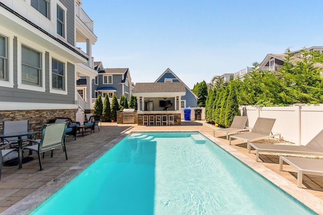 149 10th St, Avalon, NJ 08202 - view of swimming pool with a patio area, an outbuilding, a residential view, and exterior kitchen