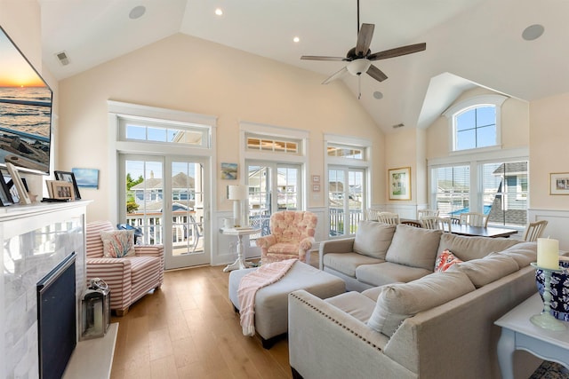 149 10th St, Avalon, NJ 08202 - living area with wainscoting, a ceiling fan, light wood-style flooring, high vaulted ceiling, and a high end fireplace
