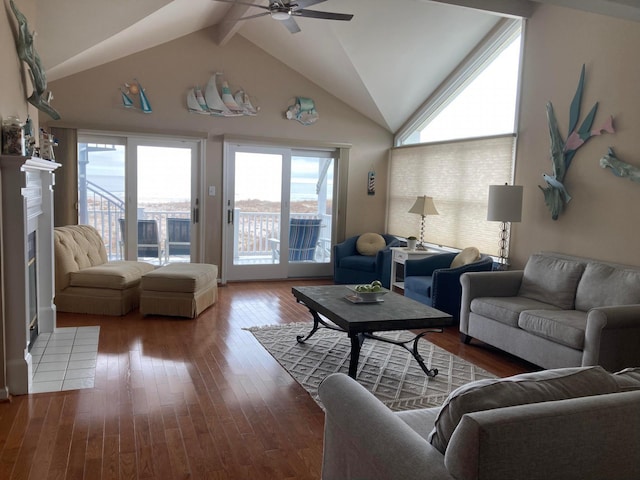 living room featuring ceiling fan, vaulted ceiling with beams, a healthy amount of sunlight, and hardwood / wood-style floors