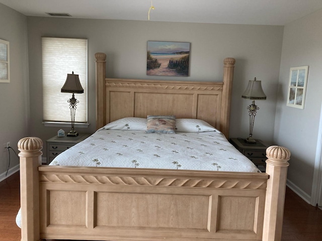 bedroom with multiple windows and dark hardwood / wood-style floors