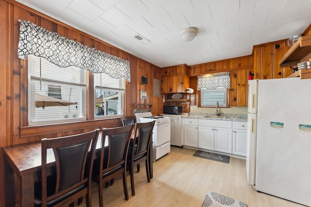 221 W 25th Ave, North Wildwood, NJ 08260 - kitchen featuring white appliances, light wood finished floors, white cabinetry, wood walls, and light stone counters