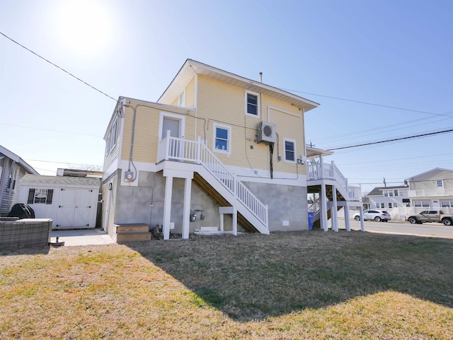 rear view of house featuring stairway, a lawn, an outdoor structure, and a shed