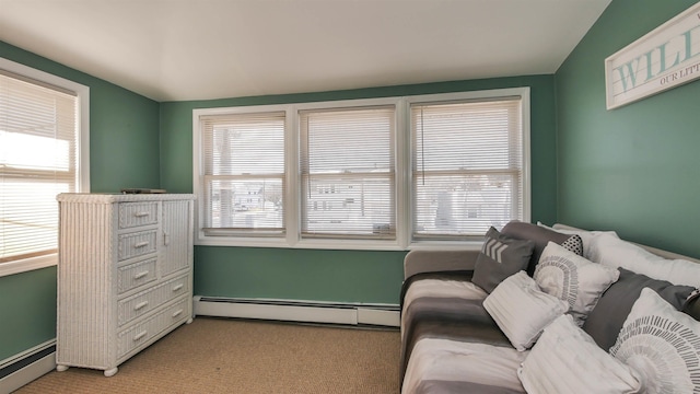 interior space with a baseboard heating unit and light colored carpet